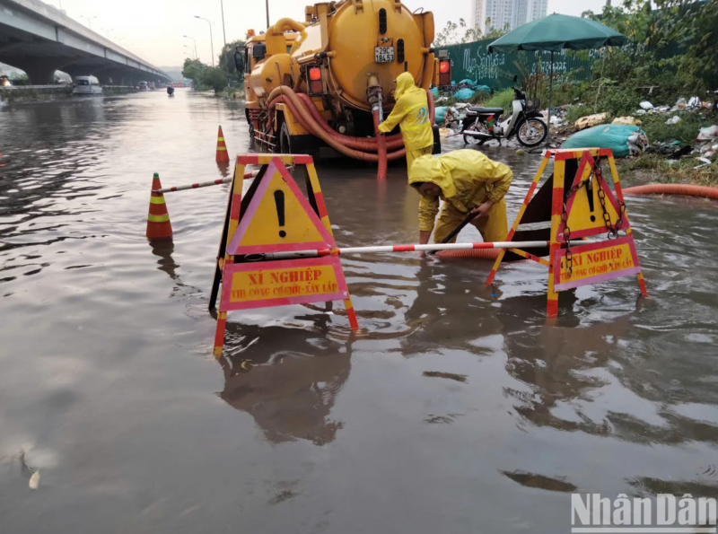 anh nguoi ha noi dung be bo tat nuoc chay may bom de chong ngap sau mua lon