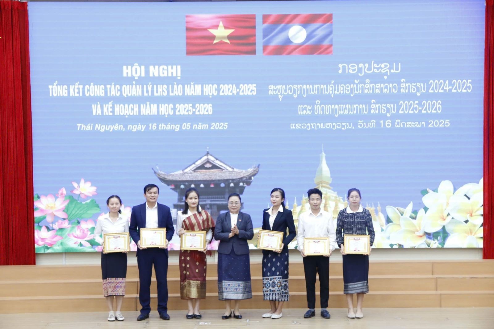 Đại sứ Khamphao Ernthavanh tặng bằng khen cho lưu học sinh Lào tại Việt Nam có thành tích xuất sắc trong học tập. (Ảnh: tnue.edu.vn)