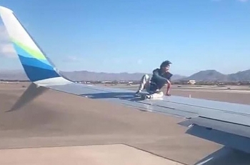 Hành khách vô tử cởi giày ngồi vắt vẻo trên cánh máy bay lúc chuẩn bị cất cánh