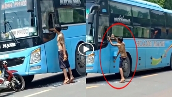 nguoi dan ong coi tran cam gach dap kinh o to khach giua duong