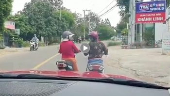 phan cam canh 2 nguoi phu nu dung xe may giua duong de buon chuyen