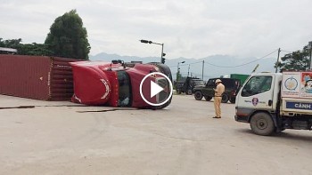 tai xe om cua qua nhanh khien chiec xe container lat nghieng