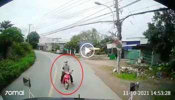 nguoi dan ong di xe may vao cua au dau dau container