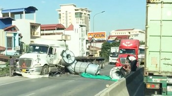 Bị container tạt đầu, xe đầu kéo rơi hàng loạt cuộn tôn xuống đường