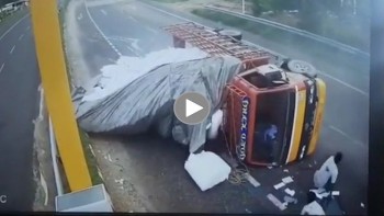 xe tai lat nghieng khi vao cua 2 nguoi dan ong vang xuong duong