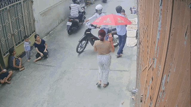 video nguoi phu nu dang di bo trong ngo cuop vut qua giat phang dien thoai tren tay